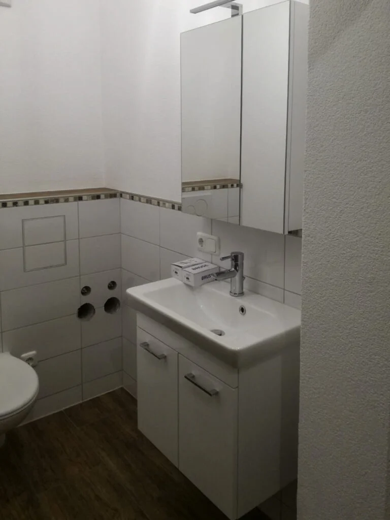 Kompaktes Badezimmer, Stanzach: Waschbecken mit Unterschrank, Spiegelschrank, Toilette, Waschmaschinenanschl&uuml;sse, wei&szlig;e Flies